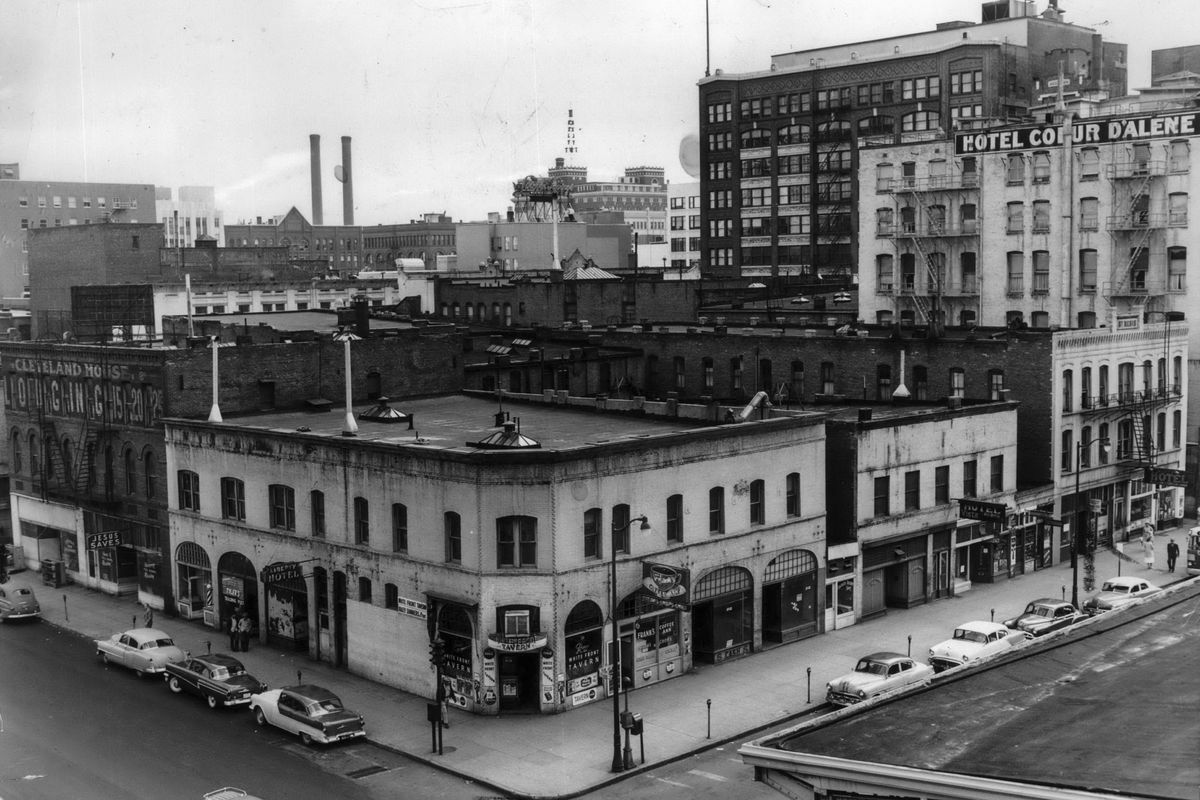 1956: The venerable row of budget hotels, bars and cafes facing Trent Avenue, originally called Front Street, mainly served the travelers who passed through the nearby rail stations and the employees who worked in the area. As transportation modes changed, an oil company leased the lot for a gas station and the buildings were torn down, a dozen years before the removal of the rails for Expo ’74.  (SPOKESMAN-REVIEW PHOTO ARCHIVES)