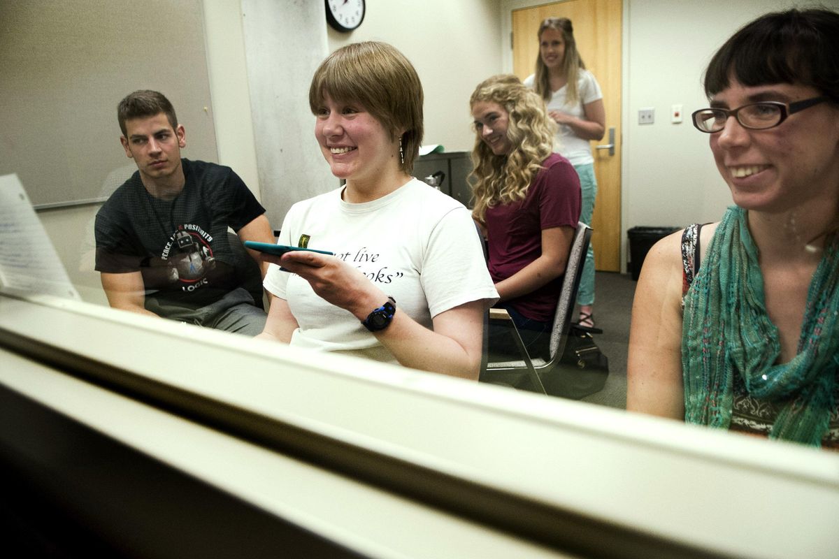 Charly Olson smiles at her reflection in a two-way mirror Friday during a speech therapy session on Friday, July 14, 2017, at  Eastern Washington University’s Health Science Building. Working with her, from  left in foreground, are clinicians Braeden Boast, Sarah Naglich and Siarah Myron. (Kathy Plonka / The Spokesman-Review)