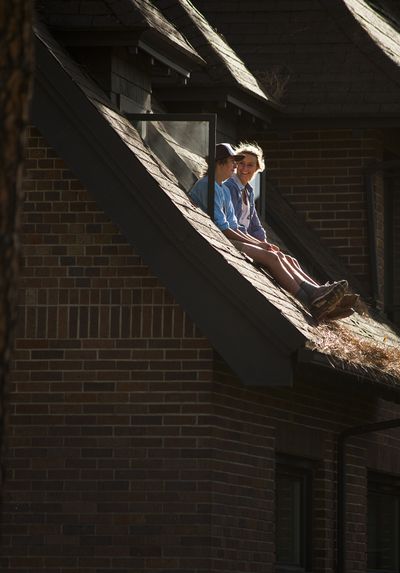 As a windstorm arrives, Whitworth University students Eli Deitz, 19, left, and Elisabeth Spencer, 20, watch pine needles fly from the window ledge of Deitz’s McMillan Hall dorm room on Tuesday. (Colin Mulvany)