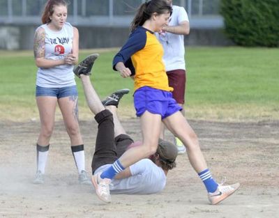 Erica Williamson (running) of The Bitters, from Perry St. Brewing Co., returns to second base to tag up after shortstop Alex Moe of The Runs catches a fly ball and falls to the ground at Grant Park during a game of kickball July 13.  (Jesse Tinsley)