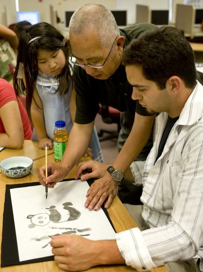 In a Mandarin Chinese course at Gonzaga University, Zong-Ren Wang, center, instructs Michael Beck in the art of Chinese watercolor painting Wednesday. The summer class is being offered through a federal government initiative for Americans to learn languages and cultures considered vital to the U.S.’ financial and security interests.  (Colin Mulvany / The Spokesman-Review)