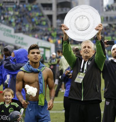 Owner Joe Roth holds up the Supporters Shield, a trophy that qualified Sounders FC for CONCACAF Champions League. (Associated Press)