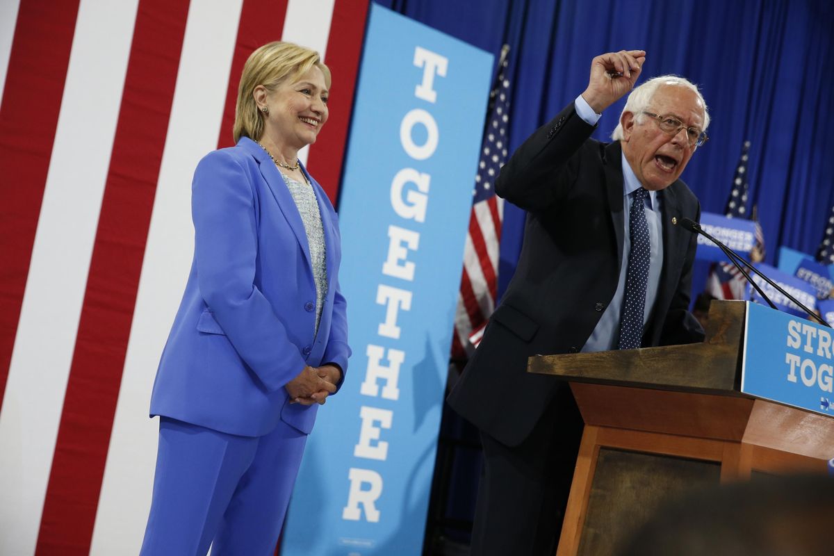 Democratic presidential candidate Hillary Clinton listens as Sen. Bernie Sanders, I-Vt. speaks during a rally in Portsmouth, N.H., Tuesday, July 12, 2016, where Sanders endorsed Clinton. (Andrew Harnik / Associated Press)