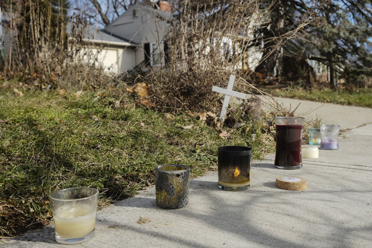 A small set of candles sit on a sidewalk near the site of a fatal police shooting, Wednesday, Dec. 23, 2020 on Oberlin Drive in Columbus, Ohio. Body camera footage released Wednesday shows Andre Hill, a 47-year-old Black man, emerging from a garage and holding up a cellphone in his left hand seconds before he is fatally shot by a Columbus police officer.  (Joshua A. Bickel)