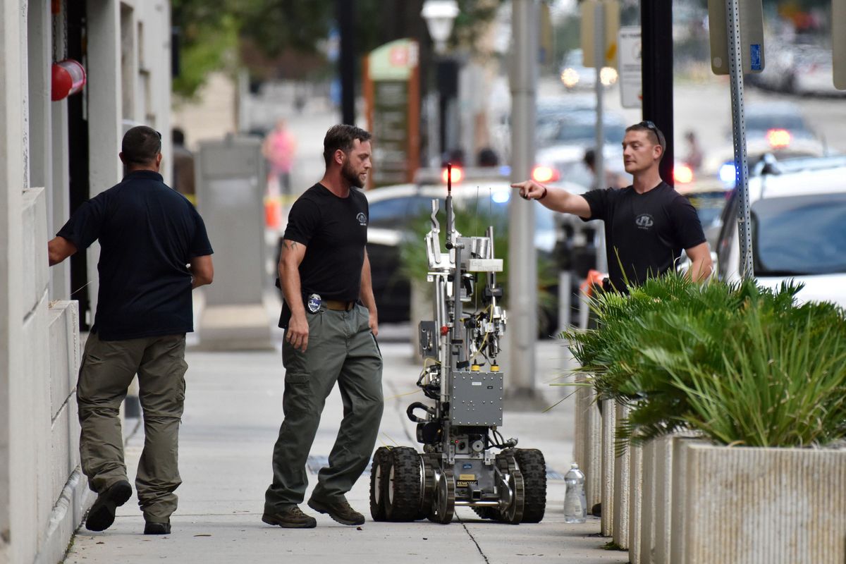 Bomb squad police prepare a robot to enter a parking garage a block away from the scene of a multiple shooting at the Jacksonville Landing Sunday, Aug. 26, 2018, during a video game competition in Jacksonville, Fla. A gunman opened fire Sunday during an online video game tournament that was being livestreamed from a Florida mall, killing multiple people and sending many others to hospitals, authorities said. (Will Dickey/The Florida Times-Union / Associated Press)