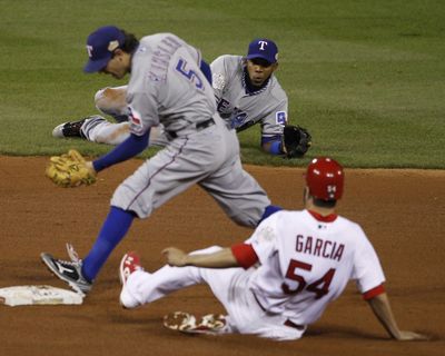 Elvis Andrus watches after flipping the ball to Ian Kinsler, who forces out Cardinals' Jaime Garcia. (Associated Press)