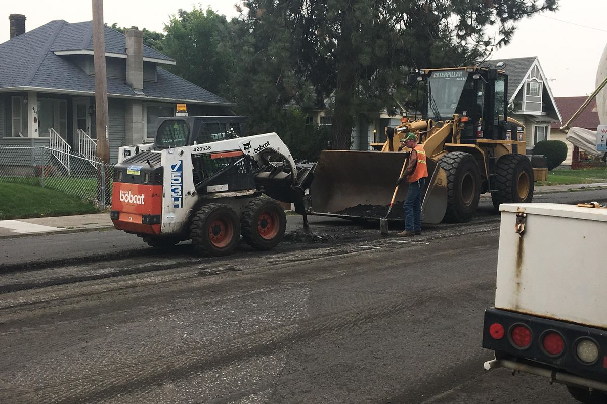 Workers break up a layer of cracked pavement as part of a repaving project on Garland Avenue on Monday. The city will perform similar maintenance on an additional 14 miles of city roads beginning next year after recieving a $5 million federal grant. (Kip Hill / The Spokesman-Review)