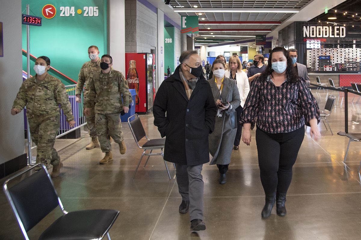 Dr. Umair Shah, the Washington state Secretary of Health, center left, gets a tour of the mass vaccination site at the Spokane Arena from Jennifer Dixon, center right, of the Department of Health on Feb. 9. Shah toured the site then headed off to the Tri-Cities to see more vaccination sites.  (Jesse Tinsley/The Spokesman-Review)