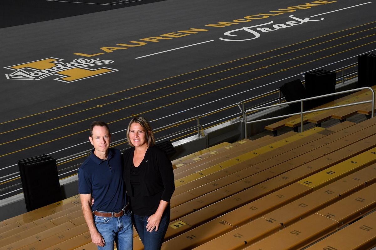 Matt and Jill McCluskey pose by the new University of Idaho track named in honor of their daughter, Lauren McCluskey, on Thursday in the Kibbie Dome in Moscow, Idaho.  (Tyler Tjomsland/The Spokesman-Review)