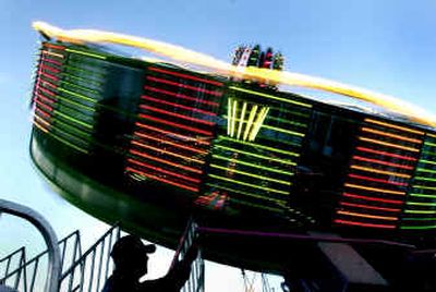 
A midway worker at the North Idaho Fair operates one of the amusements.
 (Brian Plonka / The Spokesman-Review)