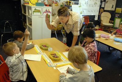 Trent Elementary full-day kindergarden teacher Mary Melby shows Nathan Daly how to raise his hand when asking a question about writing his name during school Monday. Trent has four classes of full-day kindergarden this fall, and is the only school in the East Valley school district to offer the program. This is Melby’s second year teaching full-day kindergarden. “They’re ready to learn,” she said. “I like to teach.” (J. BART RAYNIAK / The Spokesman-Review)
