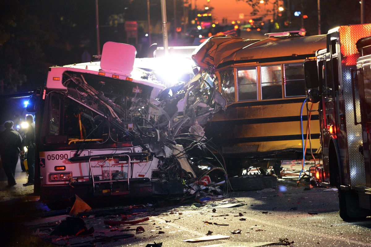 Fire department and rescue officials are at the scene of an early morning fatal collision between a school bus and a commuter bus Tuesday, Nov. 1, 2016, in Baltimore. (Jeffrey F. Bill / Baltimore Sun via AP)