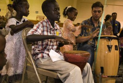 Eliow plays a djembe drum in a drum circle while his 4-year-old sister, Nebol, stands behind him at a party in his honor Saturday.
(Holly Pickett / The Spokesman-Review)
