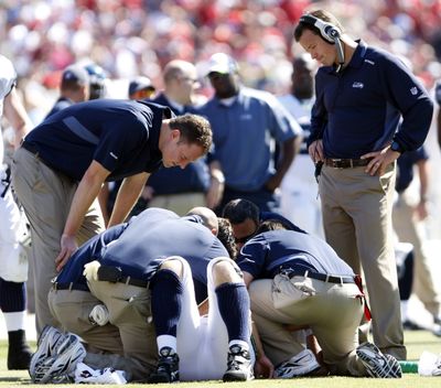 Coach Jim Mora, right, looks on last Sunday as Matt Hasselbeck is tended to. (Associated Press / The Spokesman-Review)