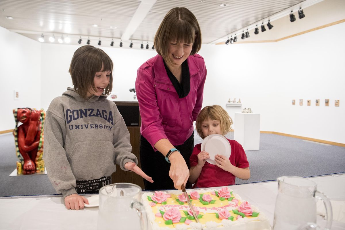 Amber Waldref, center, a former member of the Spokane City Council, cuts the cake with her daughters Karolina, left, and Nora, right, Monday, Dec. 18, 2017 at a reception before her final meeting as a sitting council member.  Attending were other council members, family and friends.  Jesse Tinsley/THE SPOKESMAN-REVIEW (Jesse Tinsley / The Spokesman-Review)