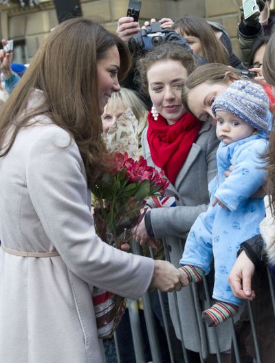 Kate, the Duchess of Cambridge, meets with a young member of the public as she arrives at the Guildhall during a visit to Cambridge, England, Wednesday. (Associated Press)