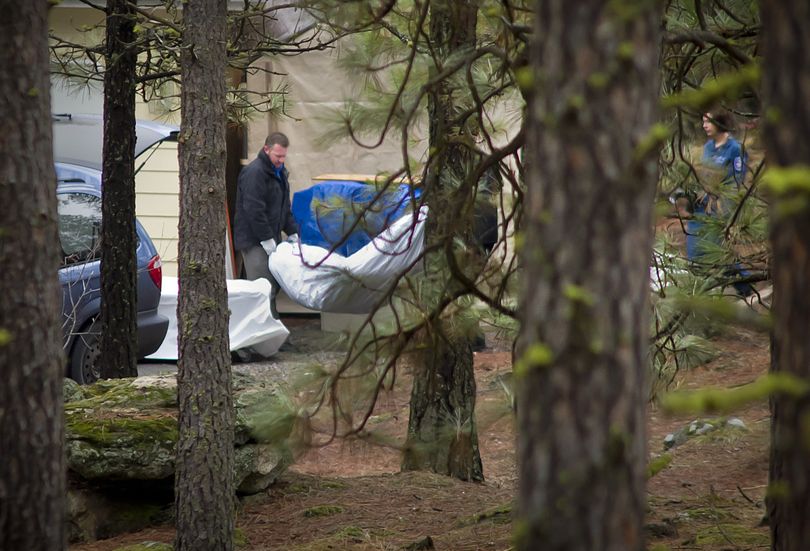 The body of Dustin Gilman is placed in the medical examiner’s van after it was discovered on property along the Little Spokane River on Monday. (Colin Mulvany)