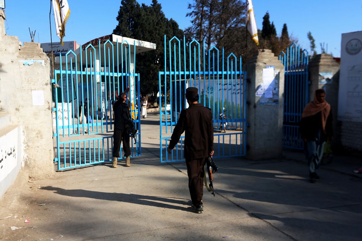 Taliban security personnel stand guard at the entrance gate of a university in Jalalabad on December 21, 2022. - Hundreds of young women were stopped by armed guards on December 21, from entering Afghan university campuses, a day after the nation