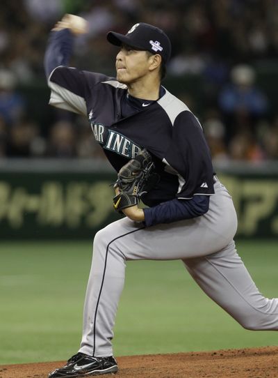 Seattle Mariners pitcher Hisashi Iwakuma throws against Japan’s Yomiuri Giants in the second inning during their exhibition game at Tokyo Dome in Tokyo Monday. The Mariners are in Japan to open Major League Baseball's 2012 season against the Oakland Athletics on Wednesday and Thursday. (Associated Press)