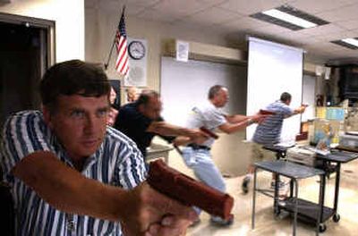 
Deputy Brett Garrett, far left, along with (from left) Detective Mark Newton, Lt. Gerry Fojtik and Deputy Samson Palmer, practices clearing a room Wednesday at Mead High School. The officers and deputies were in training to handle 