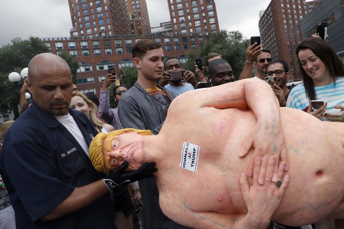 An employee of the New York City Department of Parks & Recreation removes a statue of a naked Republican presidential candidate Donald Trump on Thursday, Aug. 18, 2016, in New York’s Union Square. (Mary Altaffer / Associated Press)