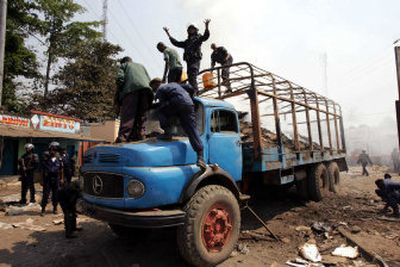 
Police stand on a truck that was carrying election papers and was set on fire by opposition party supporters in the streets of Mbuji Mayi, Congo, on Saturday. 
 (Associated Press / The Spokesman-Review)