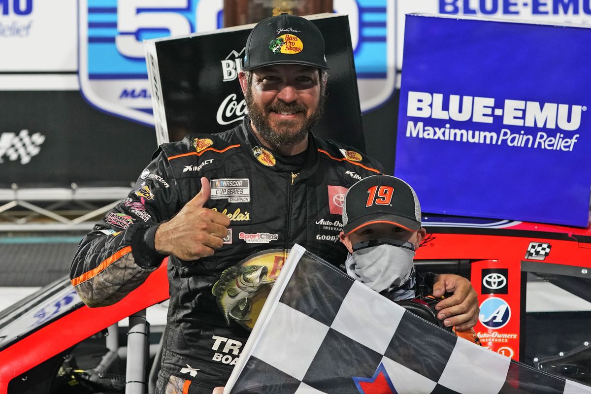 Martin Truex Jr. gives a thumbs-up as he celebrates with a fan after winning a NASCAR Cup Series auto race at Martinsville Speedway in Martinsville, Va., Sunday, April 11, 2021.  (Associated Press)