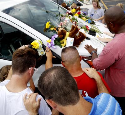 People pray around a van believed to belong to victims of a duck boat accident in the parking lot of the business running the boat tours Friday, July 20, 2018, in Branson, Mo. The country-and-western tourist town of Branson, Missouri, mourned Friday for 17 sightseers who were killed when a duck boat capsized and sank in stormy weather in the deadliest such accident in almost two decades. (Charlie Riedel / AP)