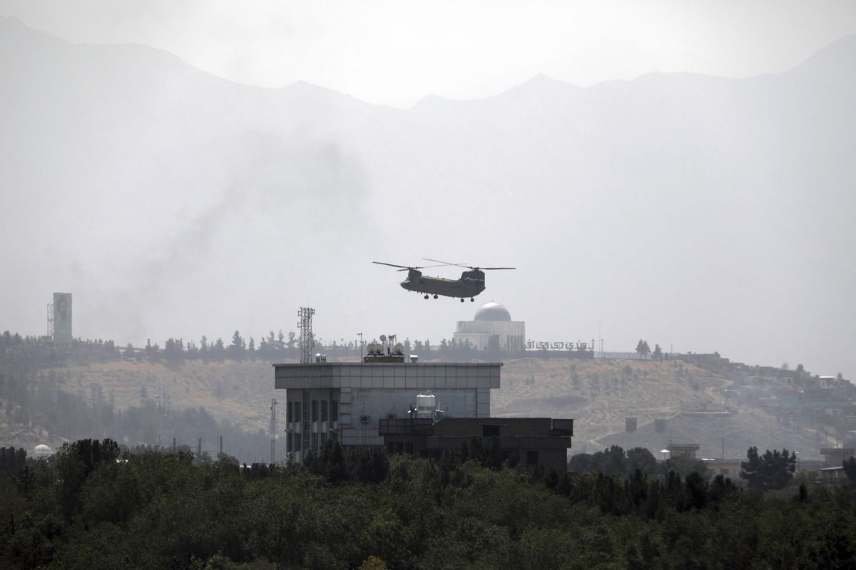 A U.S. Chinook helicopter flies Sunday over the U.S. Embassy in Kabul, Afghanistan.  (Rahmat Gul)