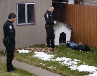 A carjacking suspect is taken into custody by Spokane Police after a police dog discovered him hiding in a doghouse in a backyard of a house on the 2500  block of North Normandie Street. (Colin Mulvany)