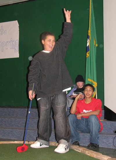 J’zon Poor, 12, a fifth-grader at Grant Elementary, celebrates hitting a putt at the First Tee program March 3.  (Pia Hallenberg / The Spokesman-Review)