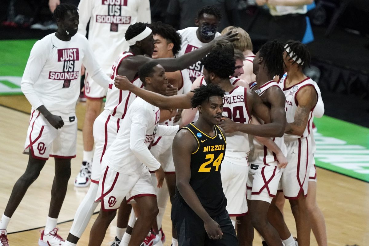 Oklahoma players celebrate as Missouri forward Kobe Brown (24) walks off the court after a first-round game in the NCAA men