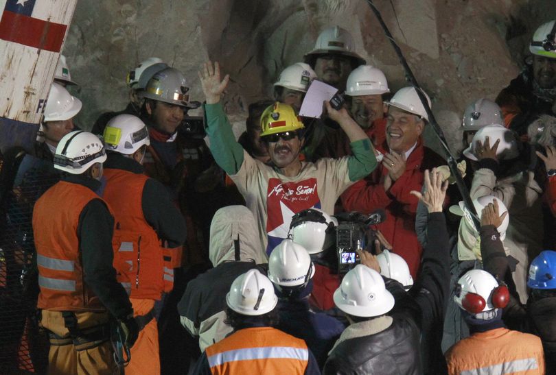 Rescued miner Juan Andres Illanes Palma, center,  third miner to be rescued, salutes at his arrival to the surface from the collapsed San Jose gold and copper mine where he was trapped with 32 other miners for over two months near Copiapo, Chile, Wednesday Oct. 13, 2010.at the San Jose Mine near Copiapo, Chile Wednesday, Oct. 13, 2010. Center right is Chile's President Sebastian Pinera. (Roberto Candia / Associated Press)