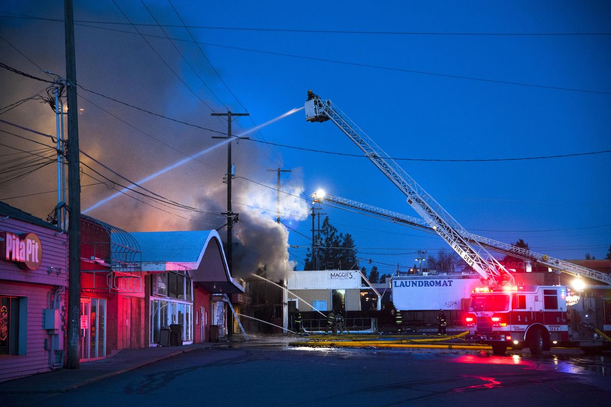 Spokane firefighters battle a blaze at the Studio K Bar & Grill at dawn, March 30, 2016, at the corner of 29th and Regal in Spokane, Wash. (Dan Pelle / The Spokesman-Review)