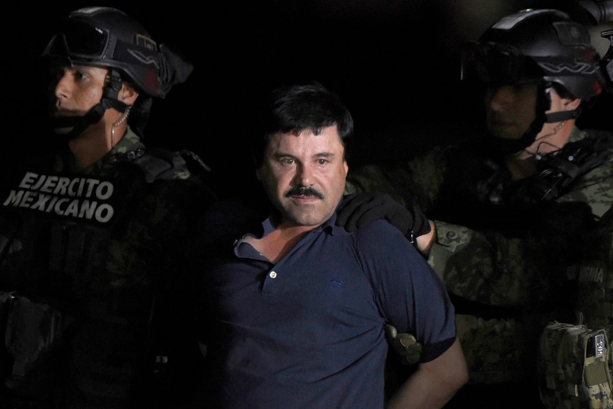 Drug kingpin Joaquin "El Chapo" Guzman is escorted into a helicopter at Mexico City