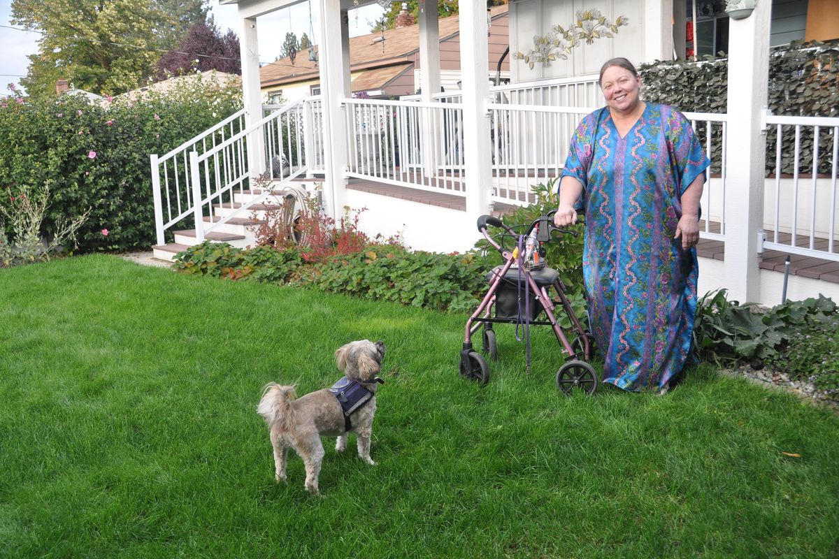 Nancy Sonduck and her service dog share a few minutes in her Shadle Park neighborhood garden. (Pat Munts / The Spokesman-Review)