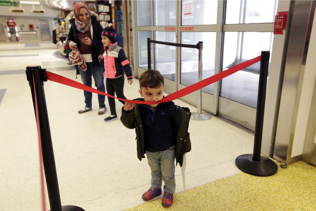 Hassan Alaskry, the son of Munther Alaskry, surveys the arrival area as his sister Dima, and mother Hiba Alaskry arrive Friday at New York’s JFK International Airport in New York. The family spent nearly a week in limbo in Baghdad. (Richard Drew / AP)