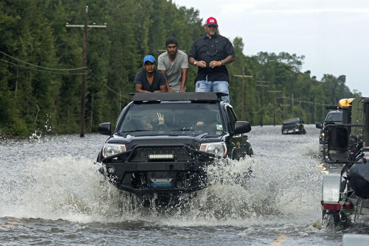 Motorists on Highway 190 drive in  deep water through Holden, La., after heavy rains inundated the region, Sunday, Aug. 14, 2016. (Max Becherer / Associated Press)