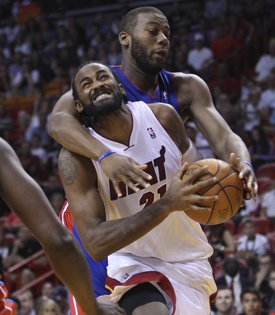 Detroit Pistons' Greg Monroe (10) fouls Miami Heats' Ronny Turiaf (21) during the first half of a NBA basketball game in Miami, Sunday, April 8, 2012. (Associated Press)