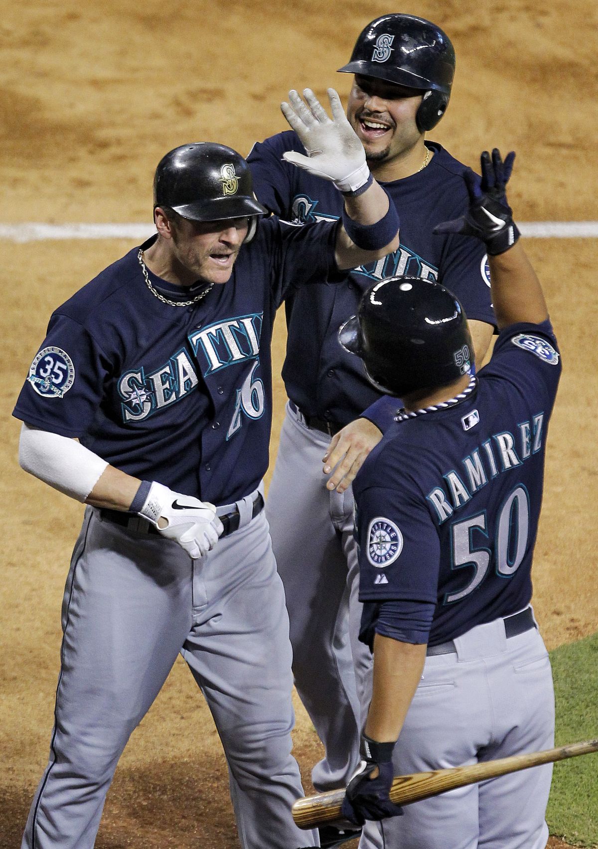M’s Brendon Ryan, left, is greeted after 3-run homer. (Associated Press)