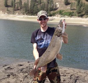 Sean Hansen of Vancouver holds a northern pike caught in the Columbia River near Kettle Falls in spring 2015. (Photo Jolley / The Spokesman-Review)