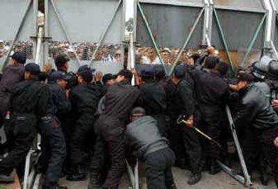 
Federal police officers try to rebuild a barricade to hold off demonstrators outside the National Congress in Mexico City. 
 (Associated Press / The Spokesman-Review)