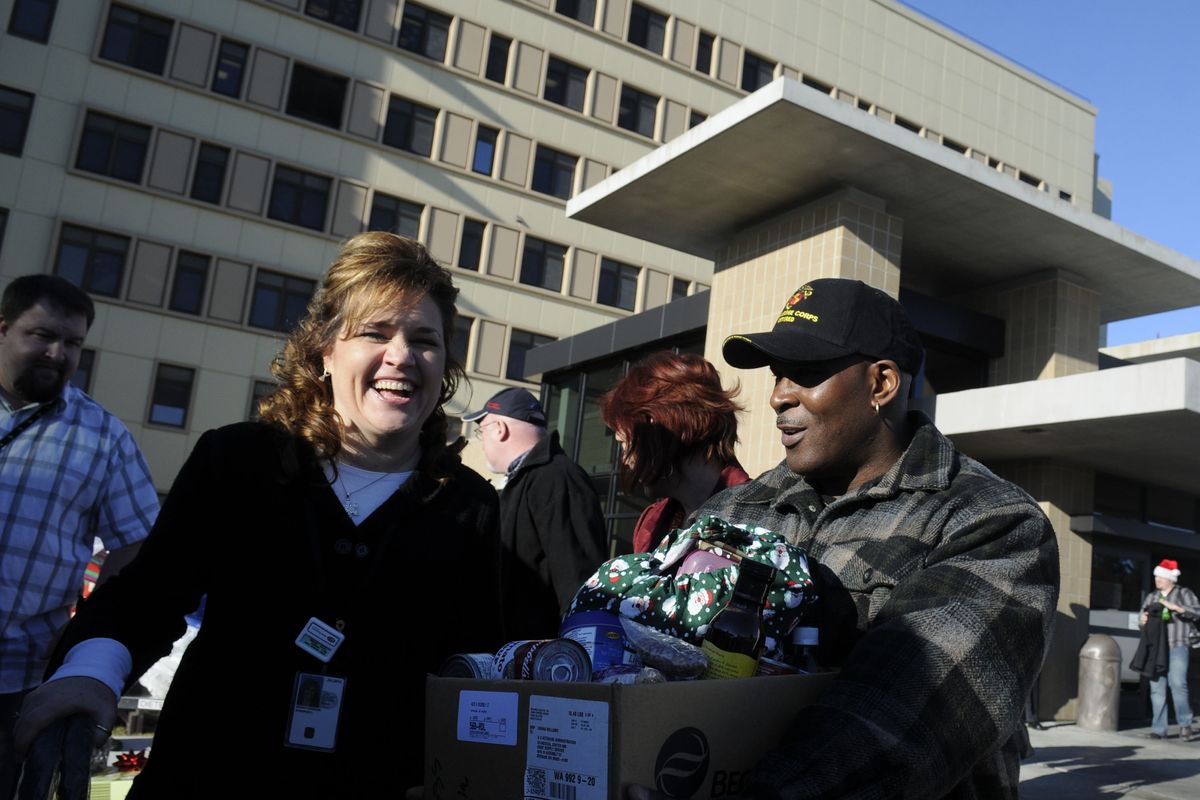 Shannon Dewey, left, and Carl Washington load gifts and food bought by the Veterans Adminstration hospital staff Wednesday, Dec. 23, 2009 outside the hospital.  More than a dozen families were "adopted" by the VA hospital staff, who delivered the gifts and food throughout the day Wednesday. (Jesse Tinsley / The Spokesman-Review)