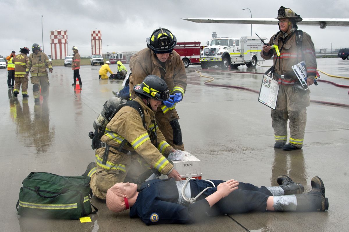 Spokane Fire Department firefighters tend to a victim in a mock airplane accident outside a donated Boeing 727 aircraft Thursday at Spokane International Airport. The full-scale drill takes place once every three years. (Dan Pelle)