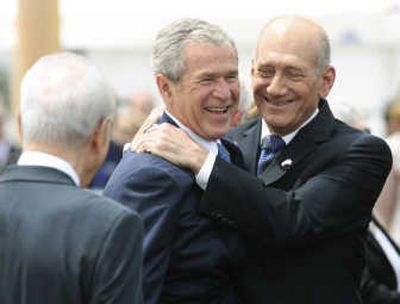 
President Bush gets a hug from Israeli Prime Minister Ehud Olmert as Israel's President Shimon Peres looks on during a welcoming ceremony at Ben Gurion airport near Tel Aviv on Wednesday. Associated Press
 (Associated Press / The Spokesman-Review)
