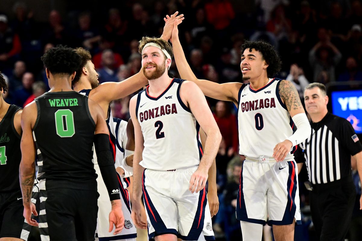 Gonzaga Bulldogs forward Drew Timme (2) smiles as forward Anton Watson (22) and guard Julian Strawther (0) high five against the Chicago State Cougars during the second half of a college basketball game on Wednesday, March 1, 2023, at McCarthey Athletic Center in Spokane, Wash. Gonzaga won the game 104-65.  (Tyler Tjomsland/The Spokesman-Review)