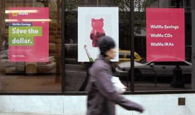 
A pedestrian walks past signs advertising bank products at a downtown Seattle Washington Mutual branch.  Associated Press
 (Associated Press / The Spokesman-Review)