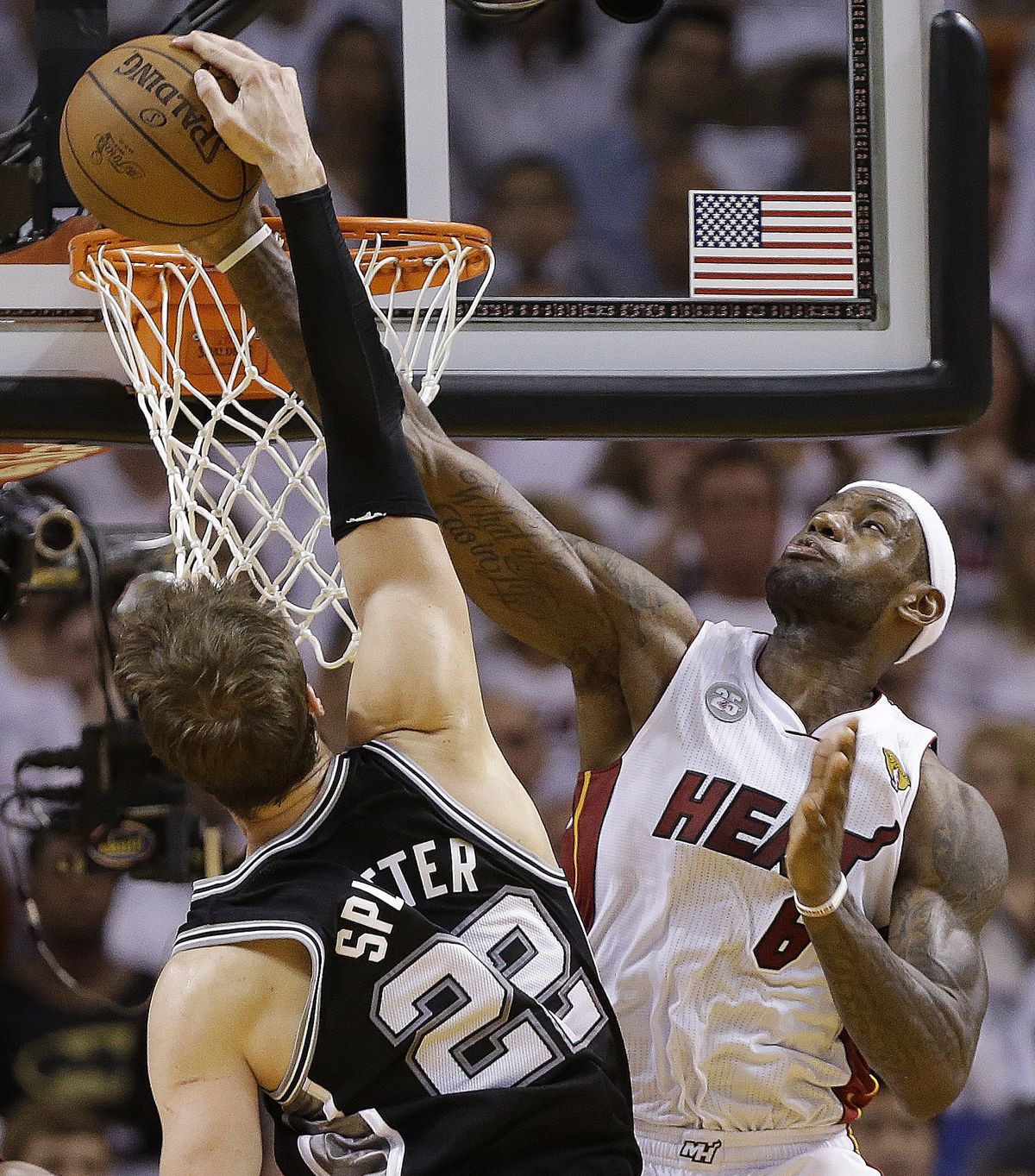 Miami’s LeBron James blocks a shot by San Antonio’s Tiago Splitter during second-half play on Sunday. (Associated Press)