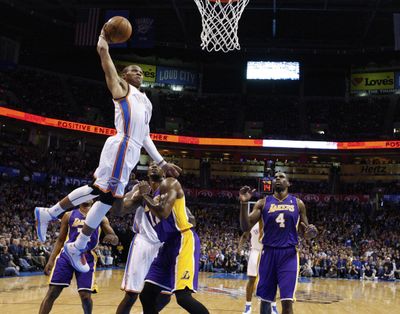OKC guard Russell Westbrook dunks in front of Dwight Howard. (Associated Press)