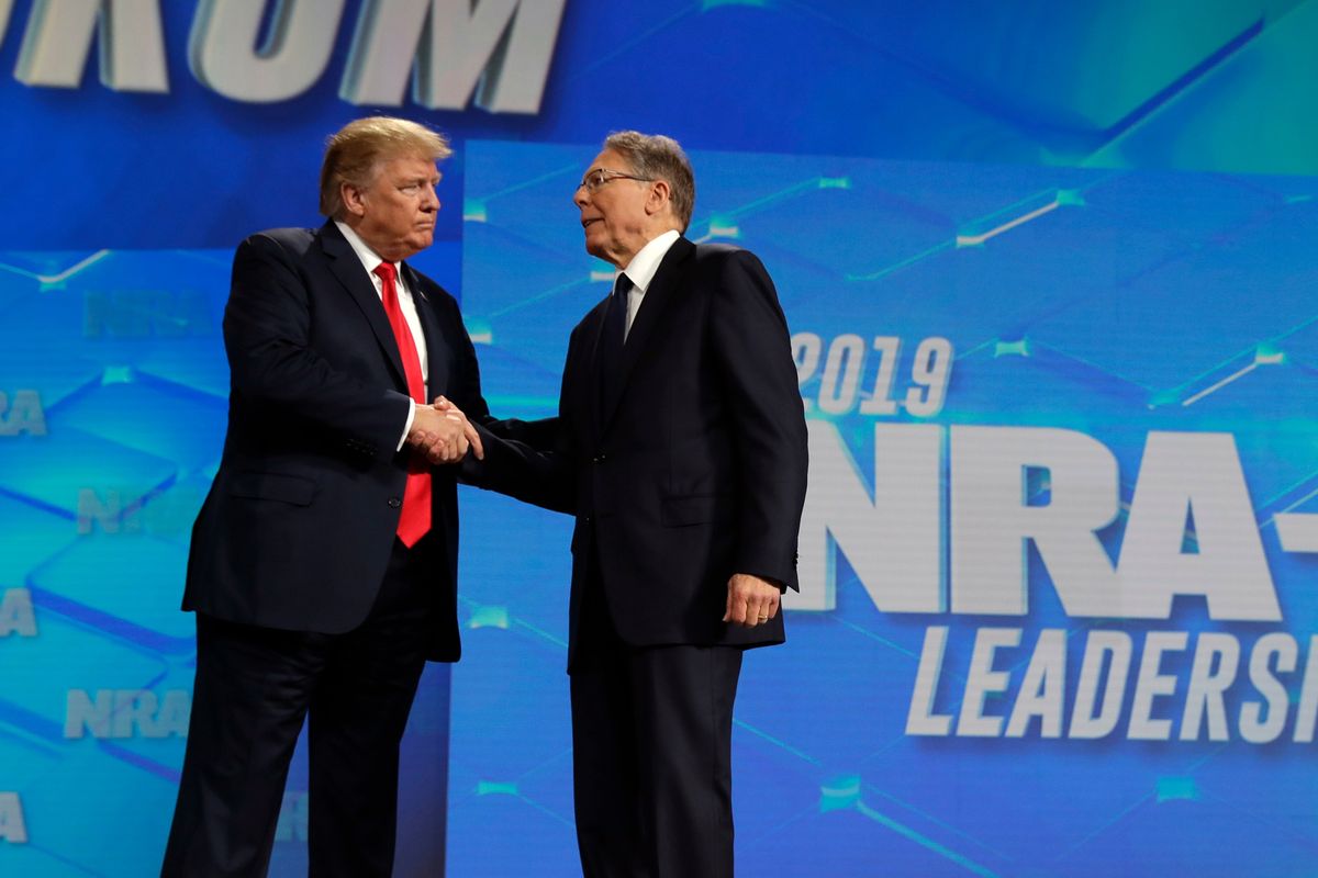 FILE - President Donald Trump shakes hands with NRA executive vice president and CEO Wayne LaPierre, has he arrives to speak to the annual meeting of the National Rifle Association, Friday, April 26, 2019, in Indianapolis. The National Rifle Association is going ahead with its annual meeting in Houston just days after the shooting massacre at a Texas elementary school that left 19 children and 2 teachers dead. With protests planned outside, former President Donald Trump and other leading GOP figures, including South Dakota Gov. Kristi Noem, will address attendees.  (Evan Vucci)